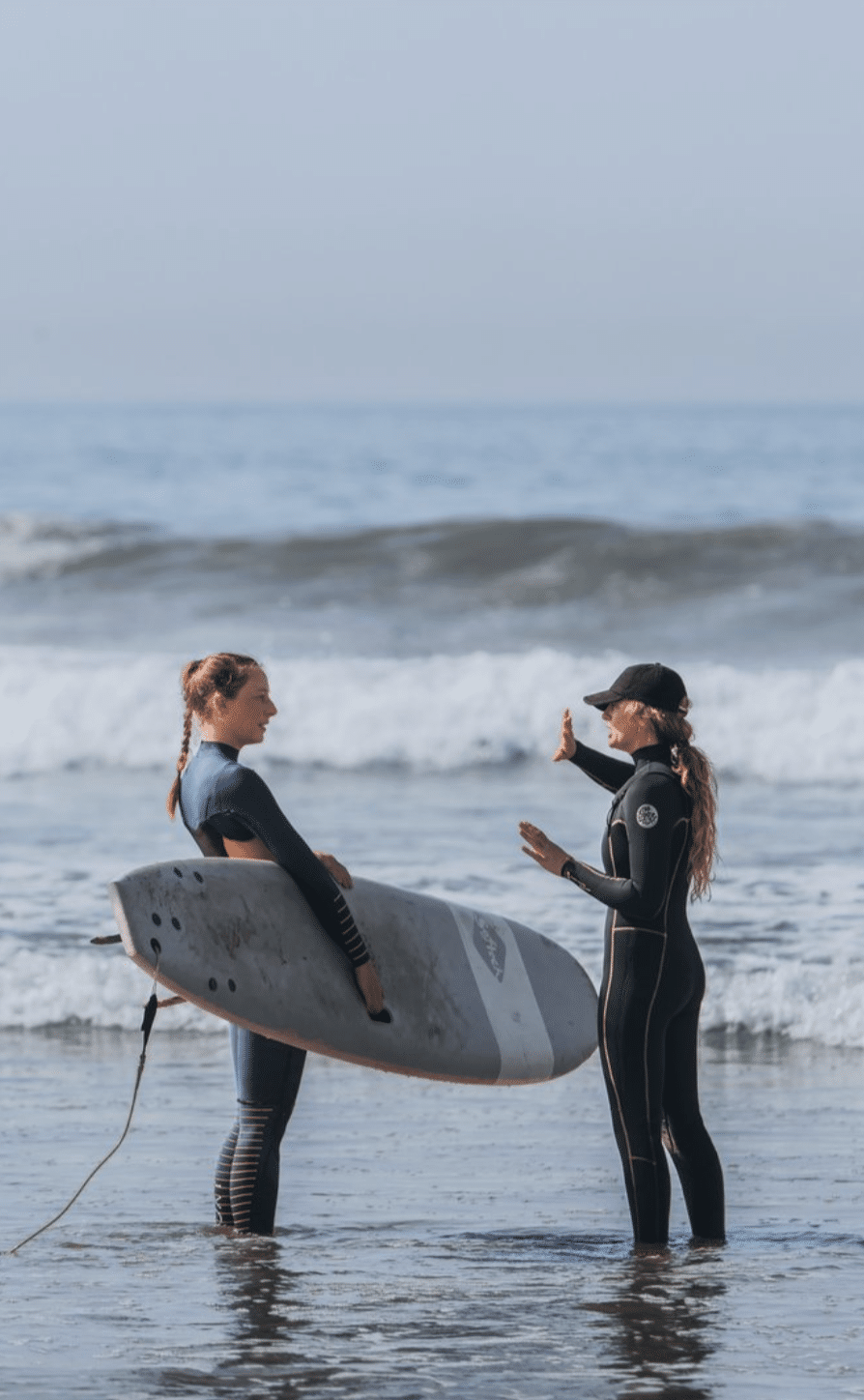 Female surf trip in Morocco - instructor coaching beginner surfer.