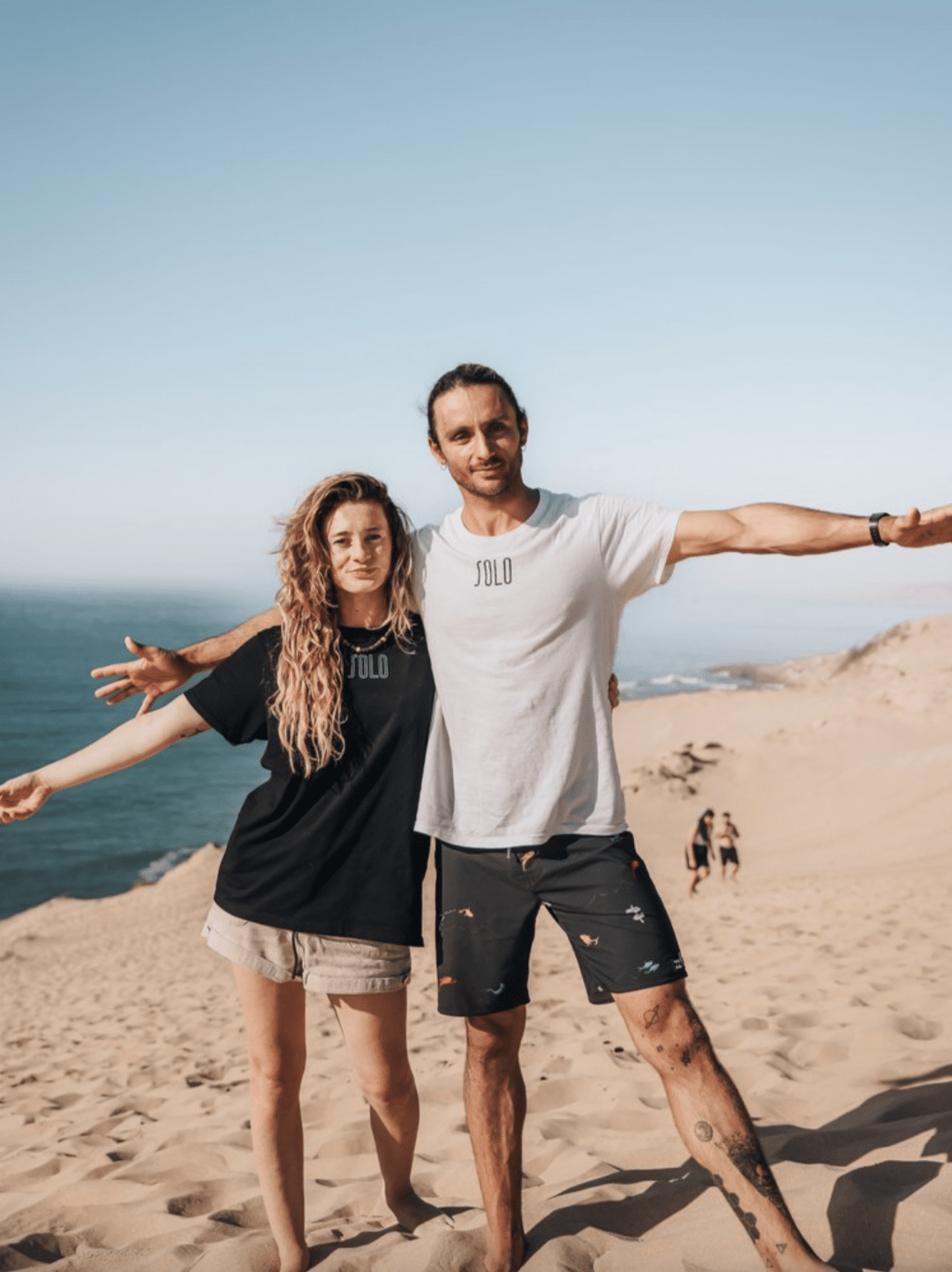 Surf Camp Co-Founders, Simone and Catharine, on the beach at a surf retreat.